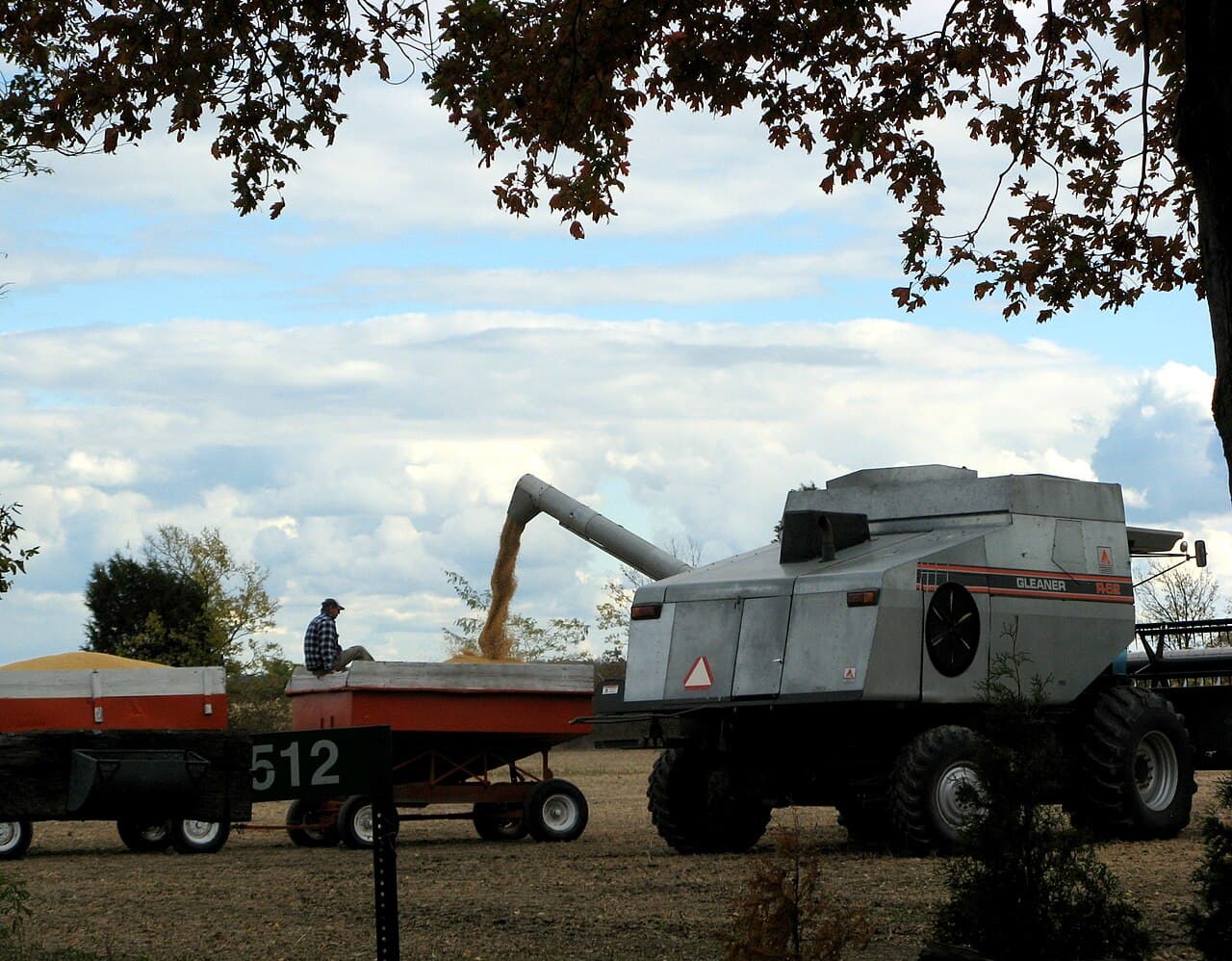 A combine unloads soybeans into a grain wagon